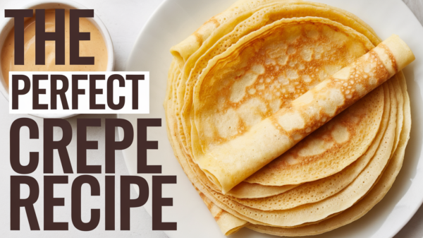 An elegant plate of golden, thin crepes folded neatly and topped with fresh berries, powdered sugar, and a drizzle of honey, showcasing the versatility of the best crepe recipe for breakfast, brunch, or dessert.